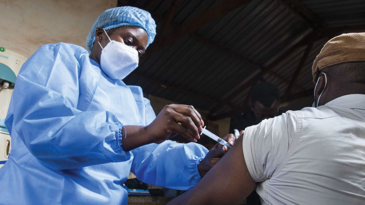 A healthcare worker in Uganda administers a COVID-19 vaccine.