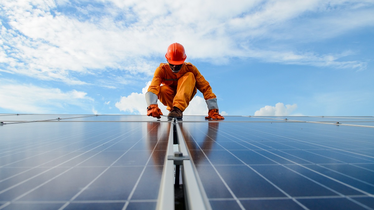 A worker installs solar panels.