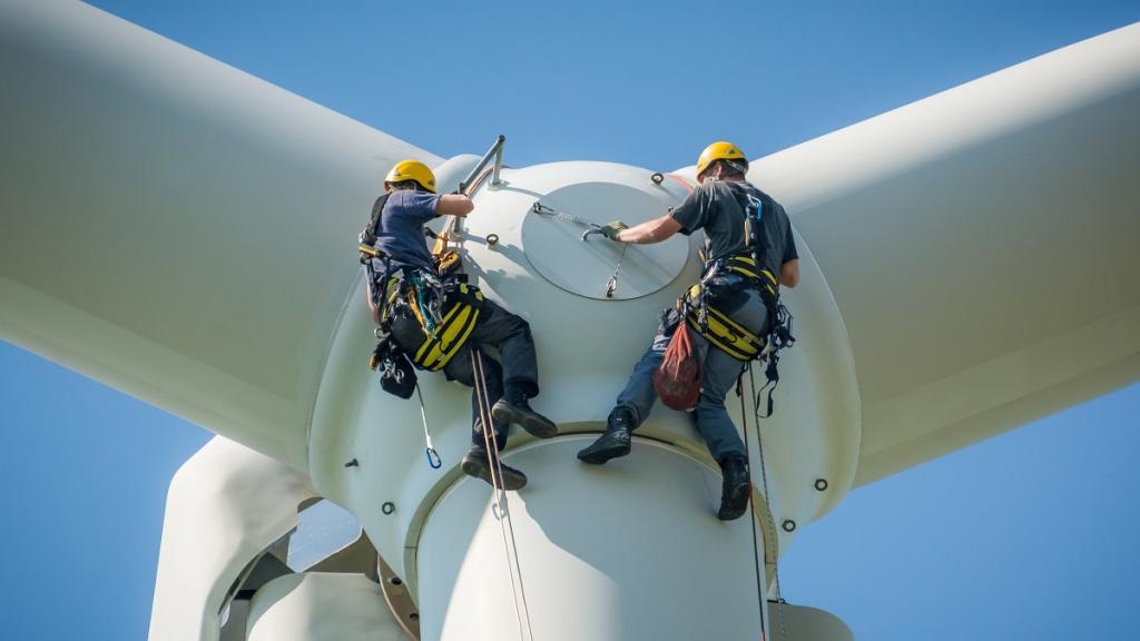 "Workers install a wind turbine."
