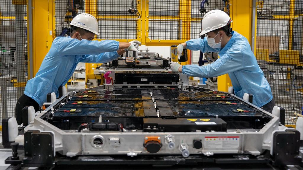 "Workers in a factory that produces electric car batteries."