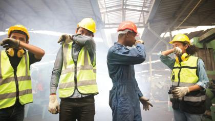 Workers in a smoke-filled factory.