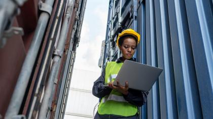 Young African American woman worker at overseas shipping container yard