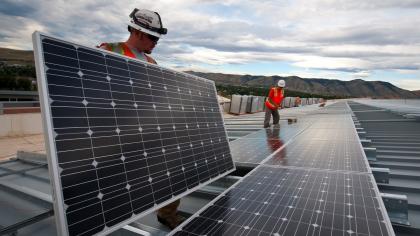 Workers install solar panels in Rio de Janeiro, Brazil