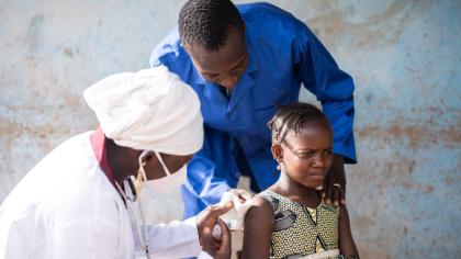 A girl is vaccinated in a village in Mali.
