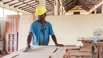 African carpenter making a door in a carpentry factory in Angola