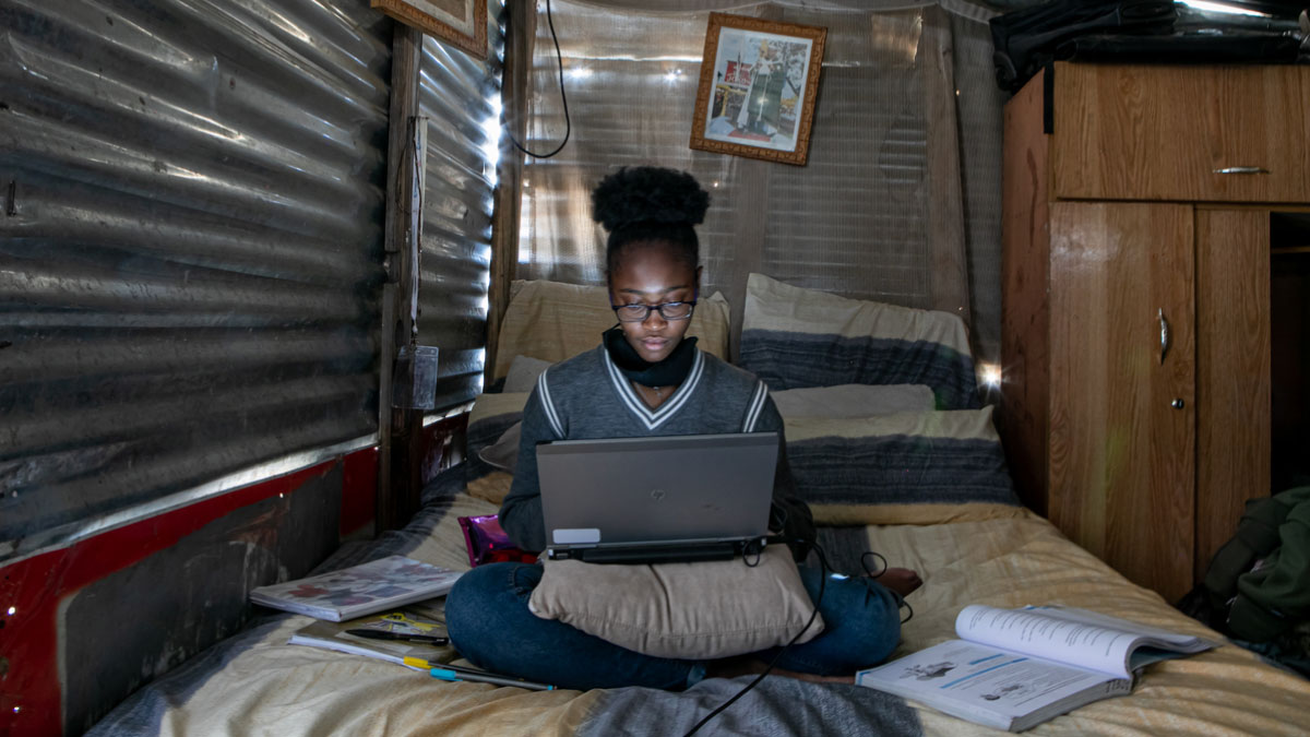 African girl studying with computer at home